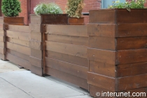 horizontal fence with green plants on wood pillars