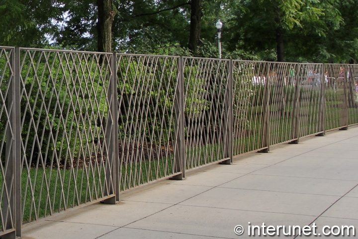 metal fence installed on top of concrete walkway