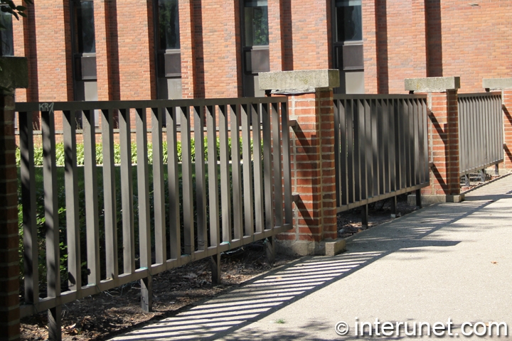 steel-fence-sections-mounted-on-brick-pillars