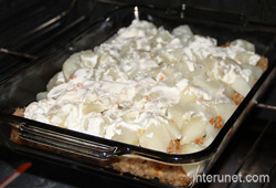 placing-ground-meat-with-potato-and-sour-cream-in-the-oven 