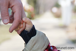 child-holding-father-hand